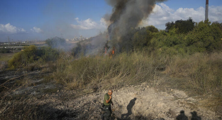 A police officer inspects the area around a fire after the military said it fired interceptors at a missile launched from Yemen that landed in central Israel on Sunday, Sept. 15, 2024. (AP Photo/Ohad Zwigenberg)