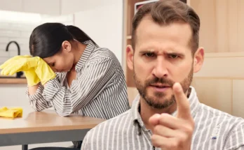 A frustrated woman trying to clean while her husband shouts | Source: Shutterstock