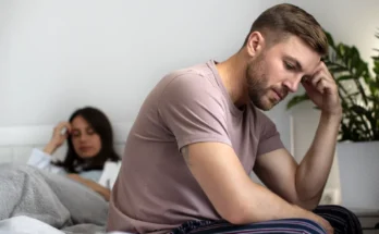 An upset couple sitting on a bed | Source: Freepik