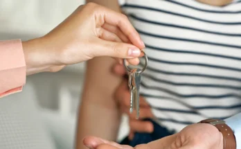 A woman giving keys to a couple | Source: Shutterstock