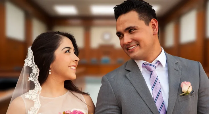 A smiling couple at a courthouse | Source: Shutterstock