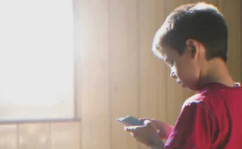 Boy using a smartphone | Source: Shutterstock
