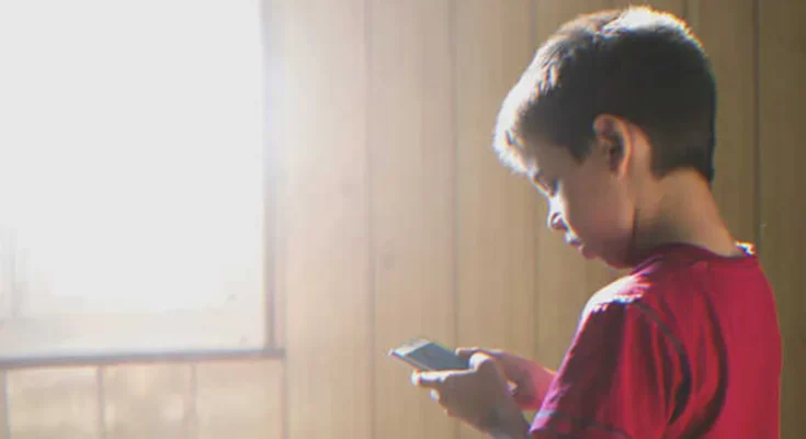 Boy using a smartphone | Source: Shutterstock