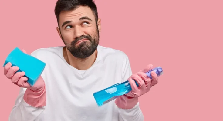 A clueless man with cleaning supplies | Source: Freepik