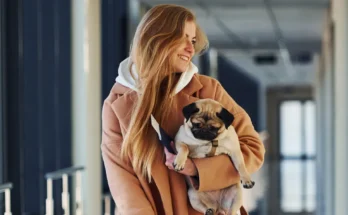 A smiling woman with a small dog | Source: Shutterstock