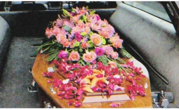 A coffin with flowers on it in a hearse | Source: Shutterstock