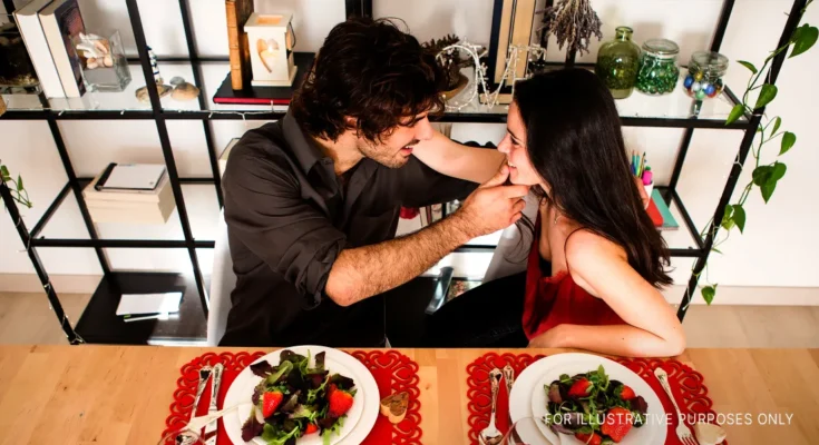 A couple touching while having a romantic dinner | Source: Flickr.com