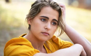 A young woman in a yellow dress lost in thought | Source: Freepik