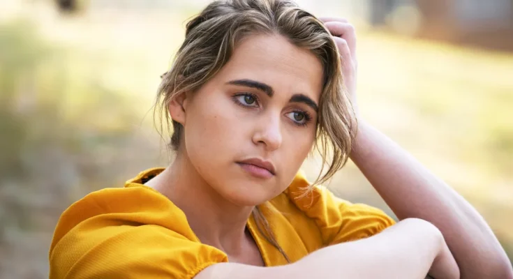 A young woman in a yellow dress lost in thought | Source: Freepik