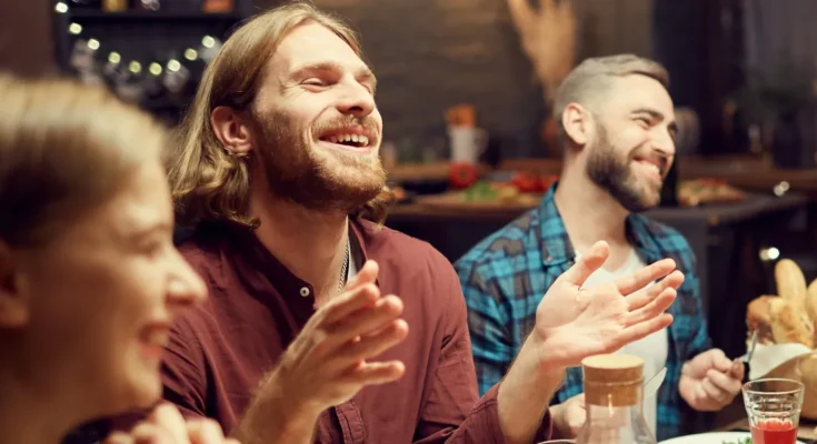 A man laughing with his friends | Source: Shutterstock