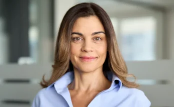 A smiling middle-aged woman standing in a modern office building | Source: Shutterstock