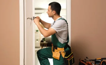 A handyman fixing a door lock | Source: Shutterstock