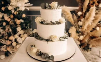 An elegant wedding cake topped with fresh roses and smooth buttercream | Source: Shutterstock