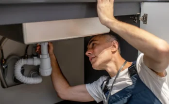 A man fixing a kitchen sink | Source: Shutterstock