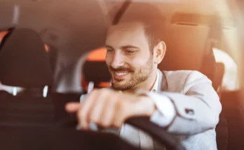 A smiling man sitting behind the wheel, enjoying the drive in his car | Source: Shutterstock