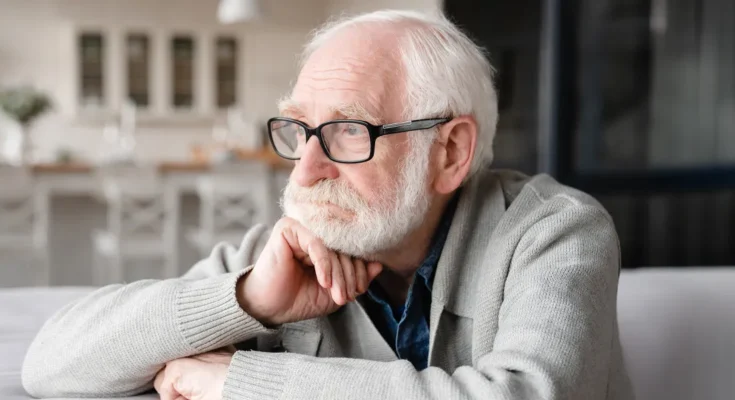 A sad old man sitting on a couch | Source: Shutterstock