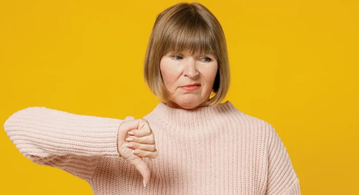 An unhappy woman giving a thumbs down sign | Source: Shutterstock