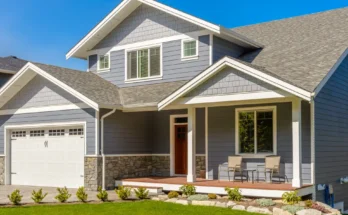 A modern two-story gray Craftsman-style home with a covered front porch and well-kept landscaping | Source: Shutterstock