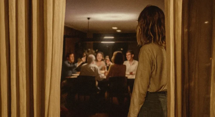 Woman observing a family gathering. | Source: Sora