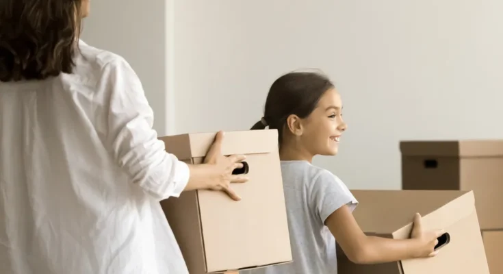 A woman and her daughter holding boxes | Source: Shutterstock