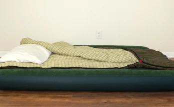 An air mattress with a sleeping bag and pillow laid out on a hardwood floor | Source: Shutterstock