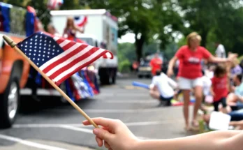 A person waving an American flag during a lively 4th of July parade | Source: Shutterstock