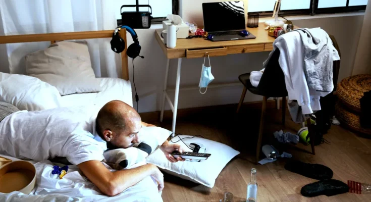 A man lying on a bed in a dirty room | Source: Freepik.com