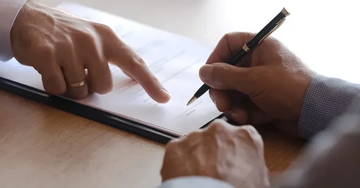 Someone signing paperwork | Source: Shutterstock