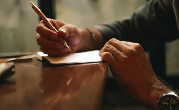 A person writing on a piece of paper | Source: Pexels