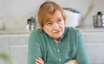 An unimpressed older woman sitting with her arms crossed | Source: Shutterstock