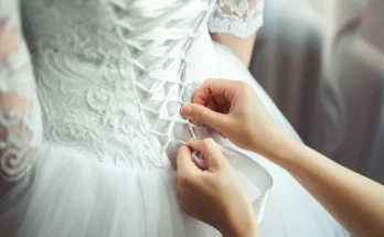 A bridesmaid making a knot on a bride's dress | Source: Shutterstock