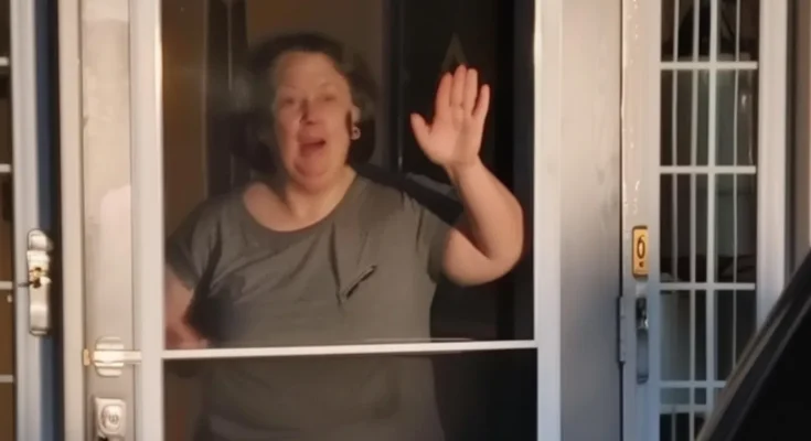 A woman waving from her house | Source: AmoMama