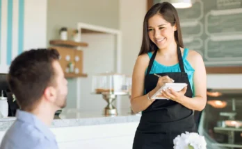 A man speaking to a smiling waitress | Source: Shutterstock