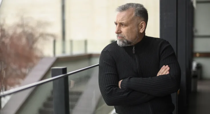 A stern man standing on a balcony | Source: Freepik
