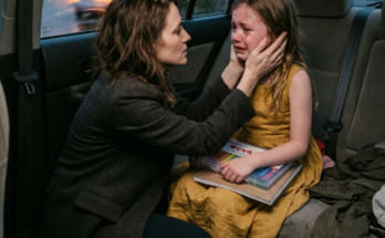 Woman holds girl's face